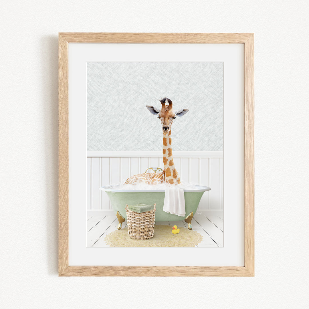 A giraffe sitting in a green bathtub filled with bubbles, surrounded by a basket of toys and a yellow rubber duck.