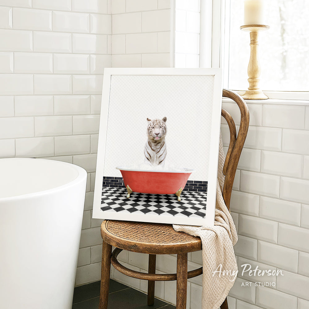 A framed image of a tiger sitting in a red bathtub, with a black and white checkered floor in the background.