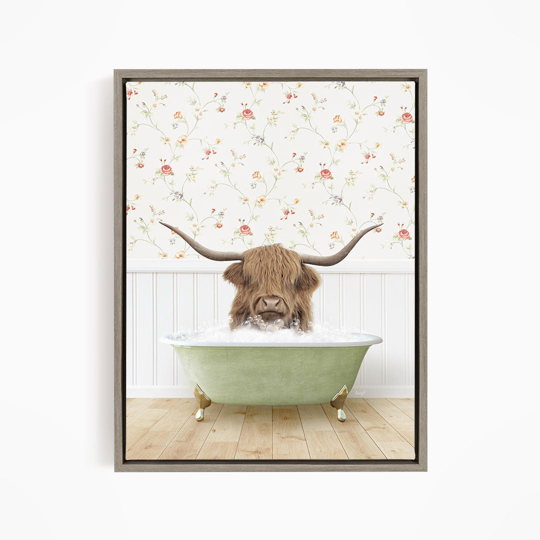 A brown cow with long horns is sitting in a green bathtub filled with water, surrounded by a floral wallpaper.