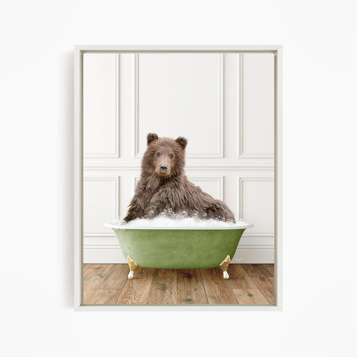 A brown bear sitting in a green bathtub filled with bubbles, looking directly at the camera.