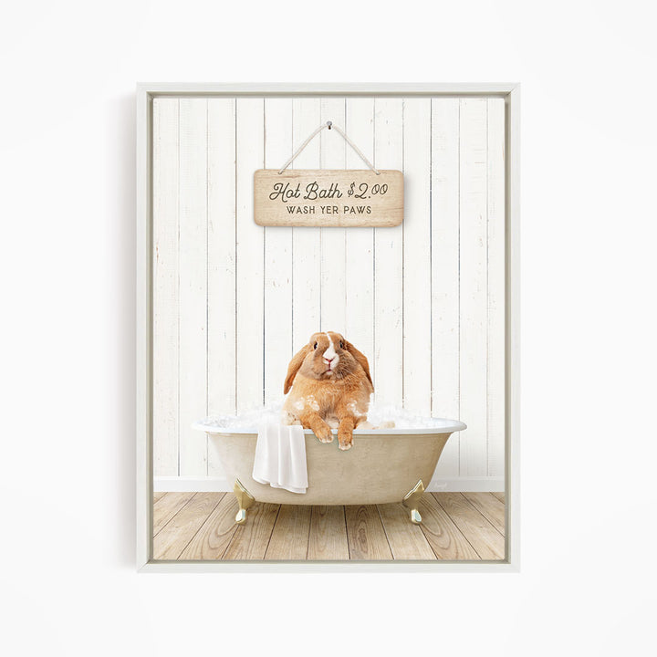 A brown rabbit sitting in a white bathtub, with a wooden sign above it that reads "Hot Bath $2.00 WASH YOUR Paws".