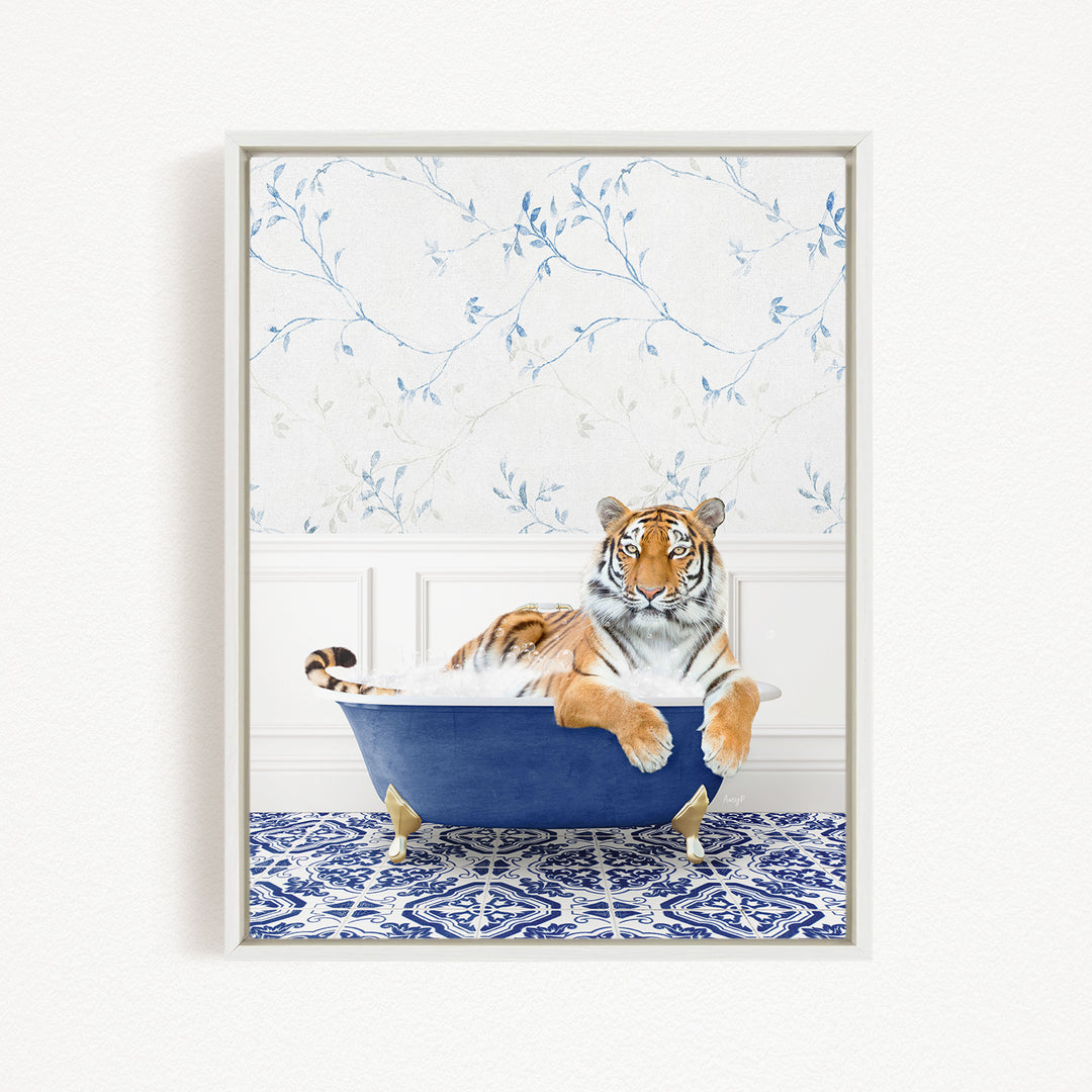 A tiger is sitting in a blue bathtub, surrounded by a blue and white patterned rug and a floral wallpaper background.