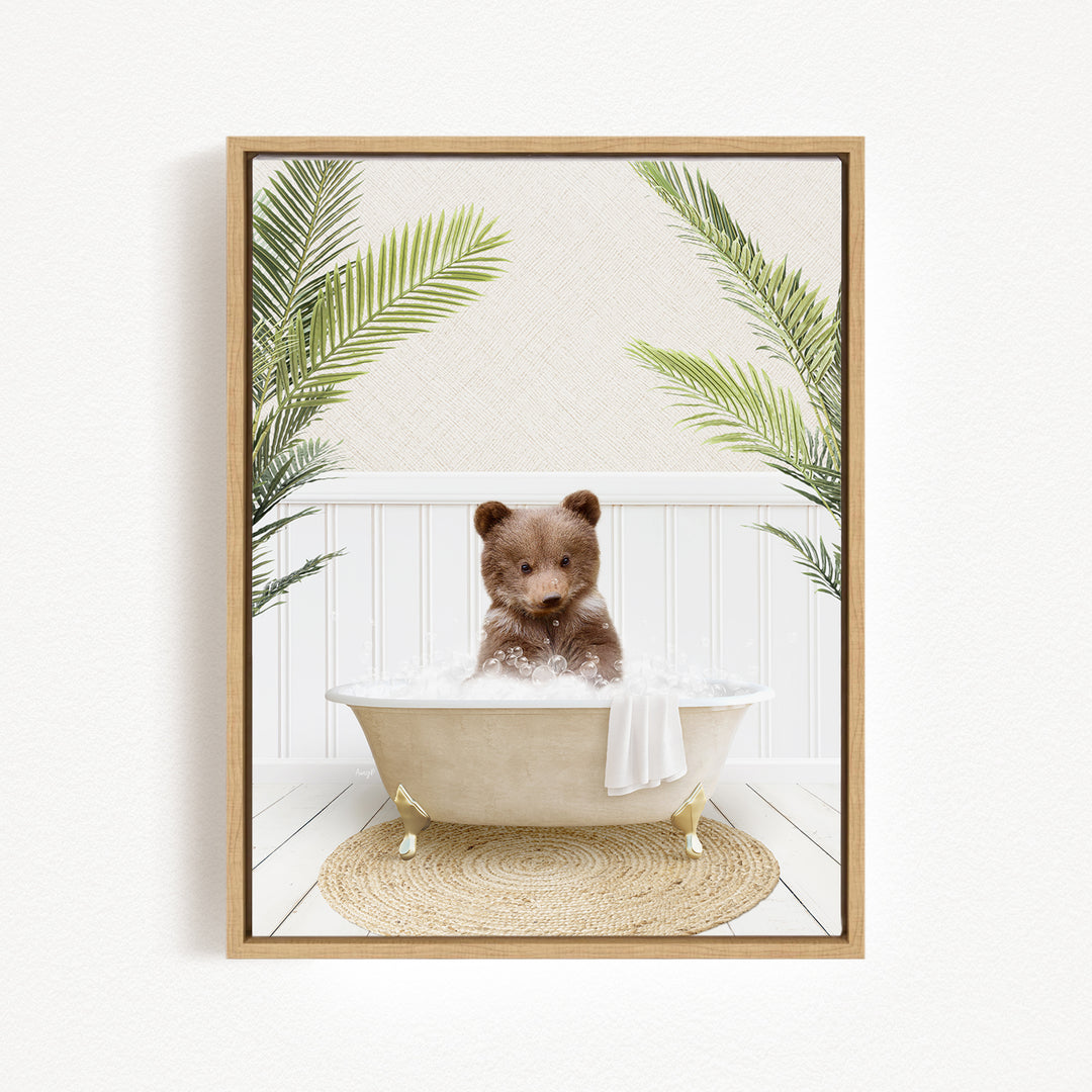 A brown bear sitting in a white bathtub filled with bubbles, surrounded by green palm leaves.