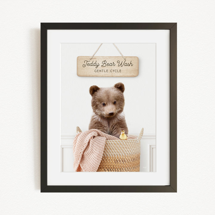 A framed image of a teddy bear sitting in a basket, with a sign above that reads "Teddy Bear Wash Gentle Cycle".