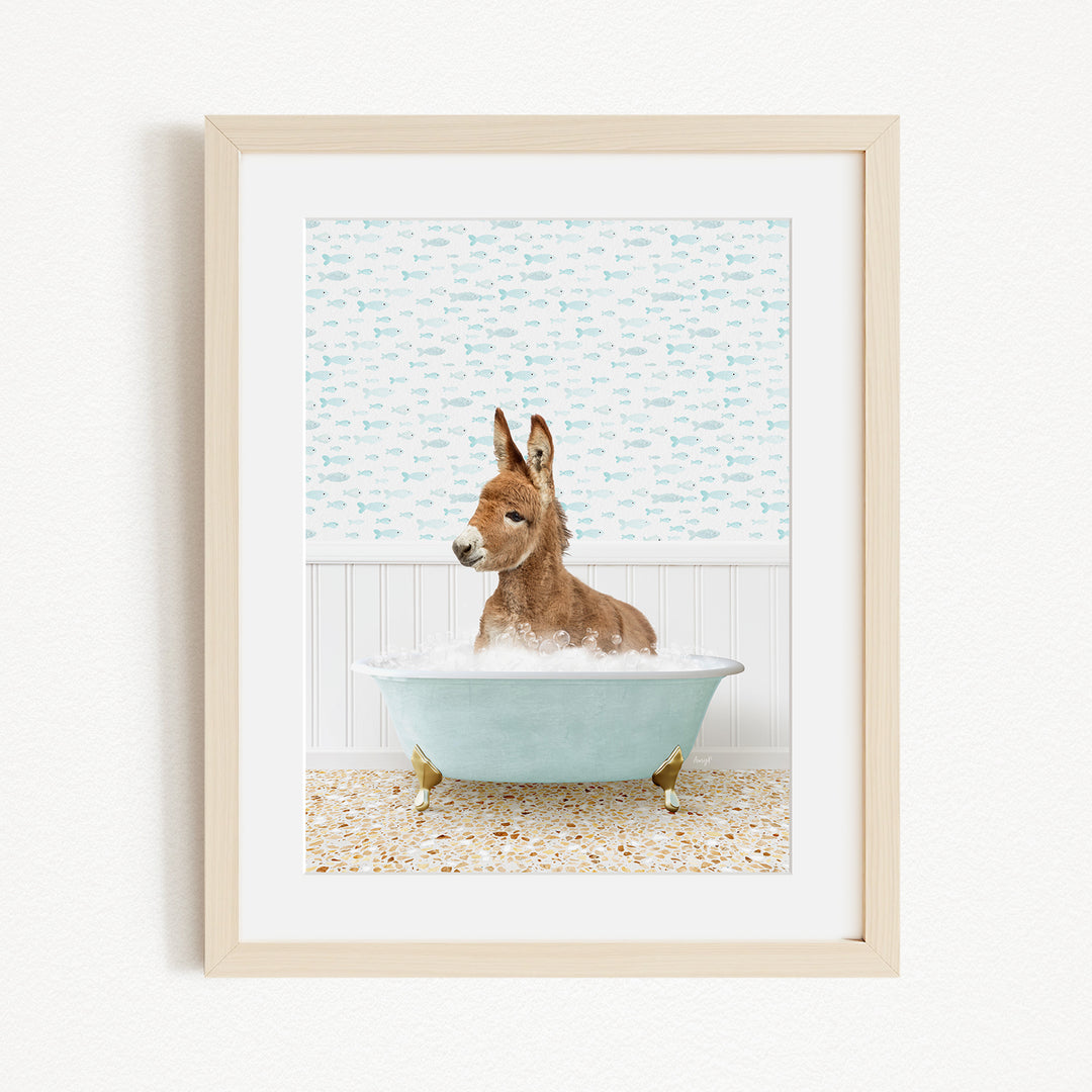 A donkey is sitting in a blue bathtub filled with bubbles, surrounded by a patterned wall and a beige floor.