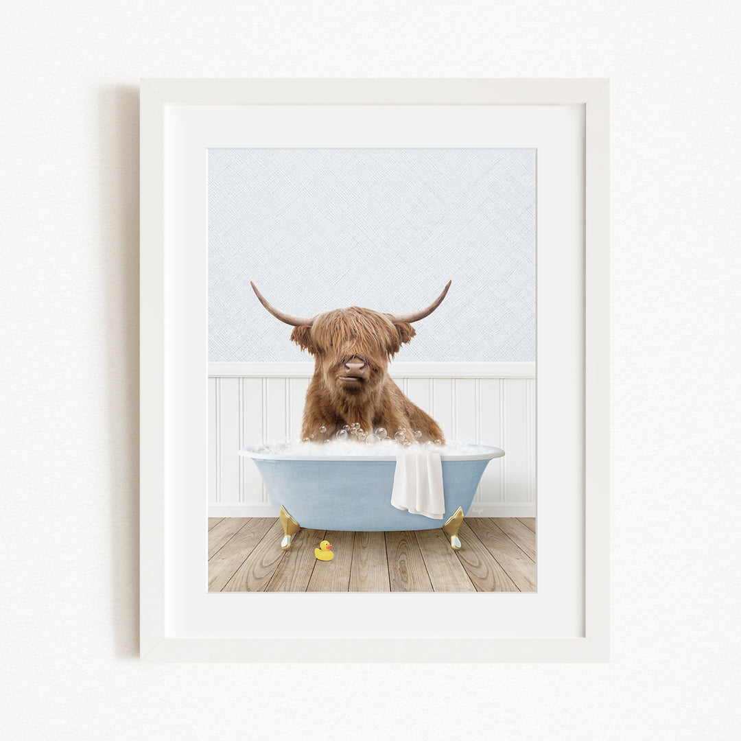 A brown cow with long horns is sitting in a blue bathtub filled with water, surrounded by yellow rubber duckies.