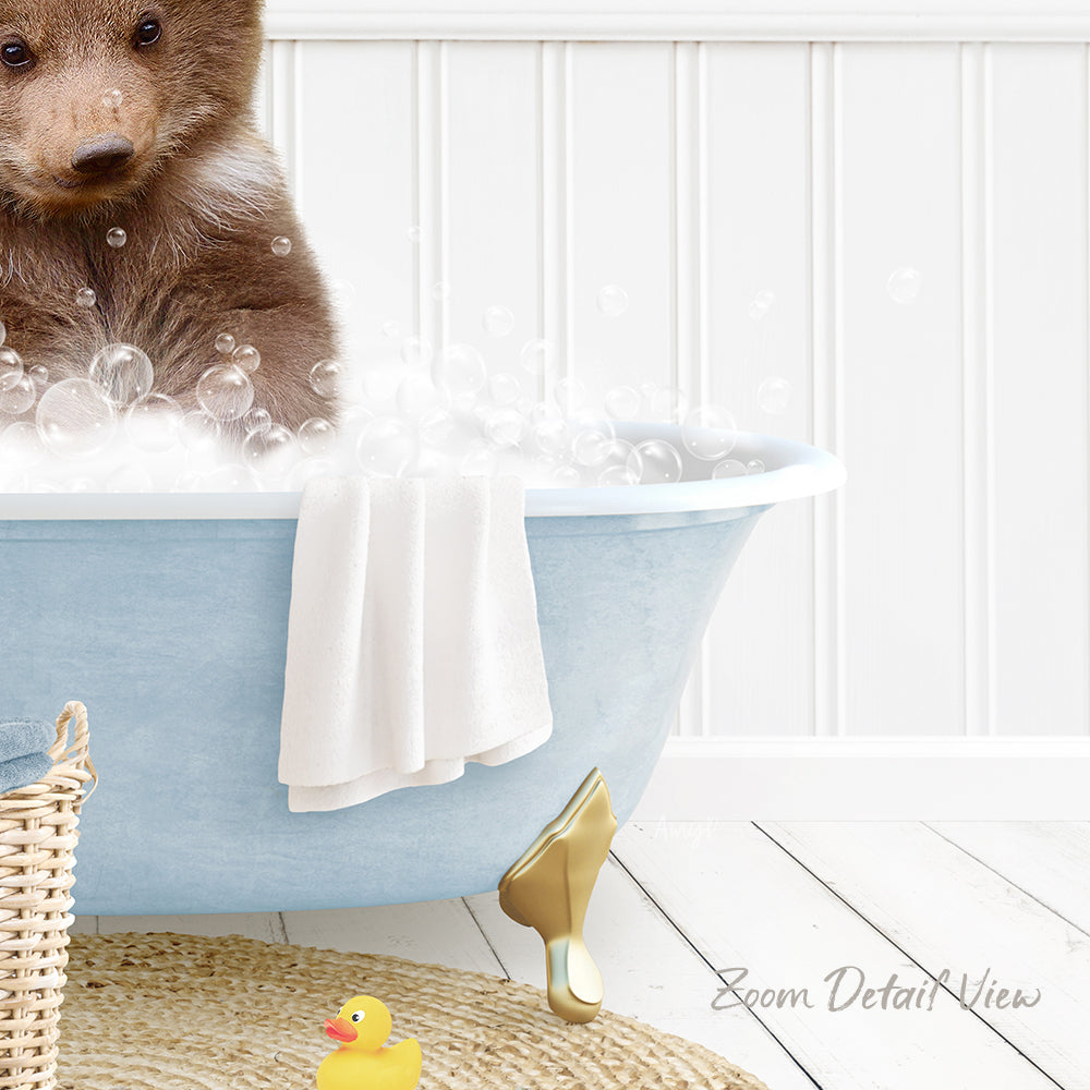 A brown bear is sitting in a blue bathtub filled with bubbles, surrounded by a yellow rubber duck and a white towel.