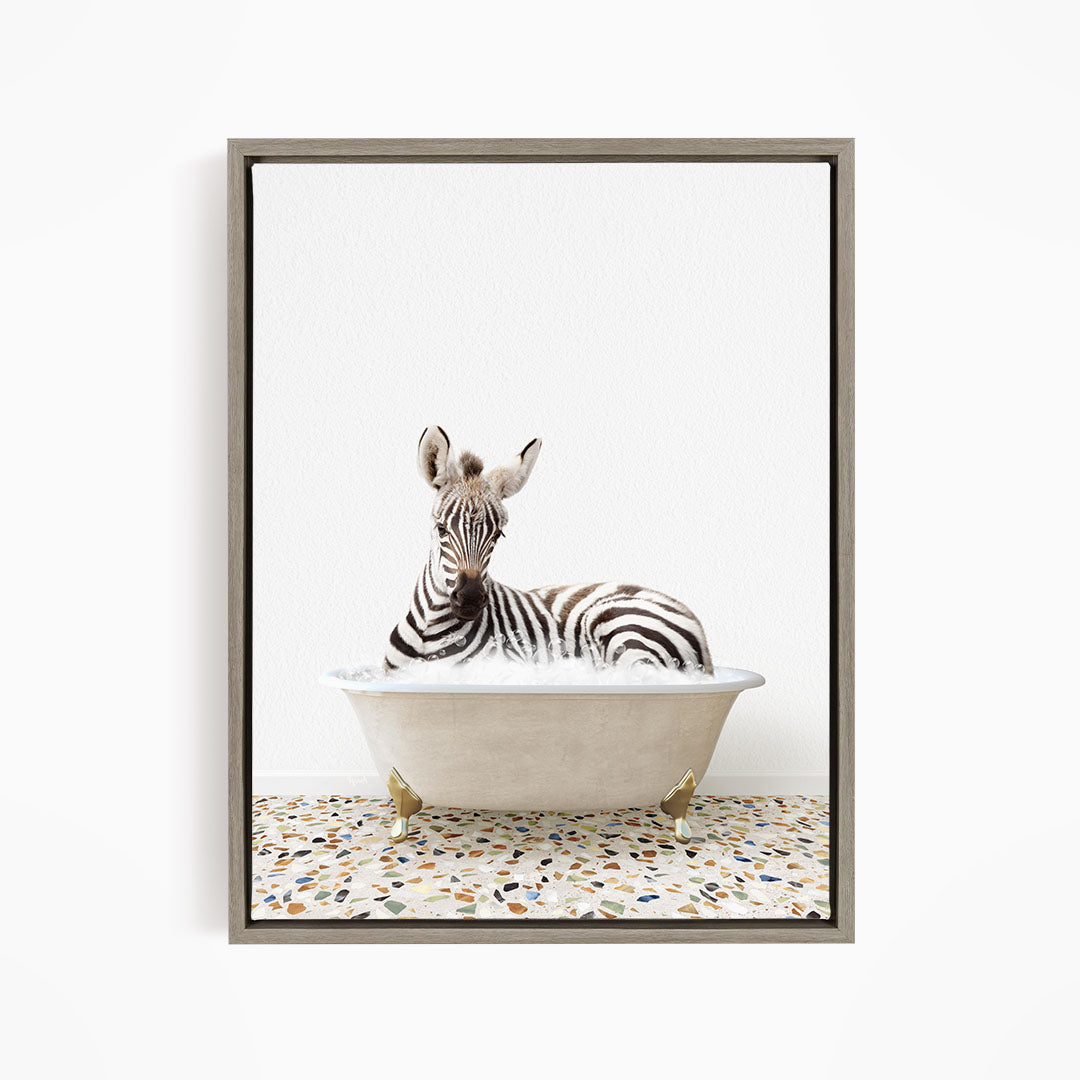 A zebra is sitting in a bathtub, surrounded by a speckled floor.