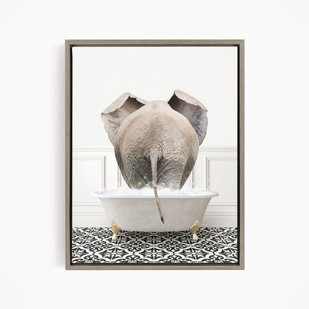 A gray elephant is standing in a white bathtub filled with water, with its trunk submerged in the water.