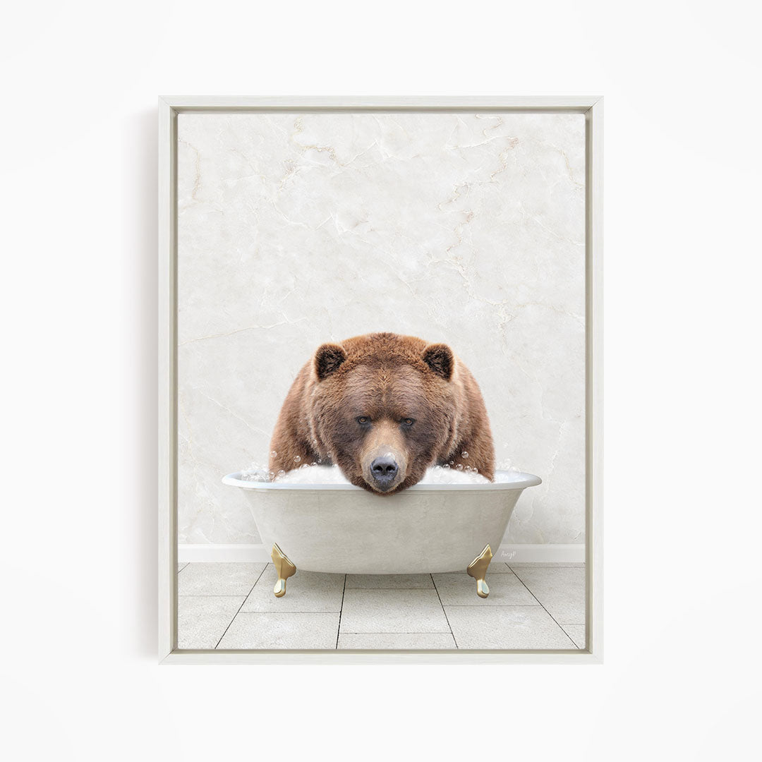A brown bear is sitting in a white bathtub, appearing to be enjoying a relaxing bath.