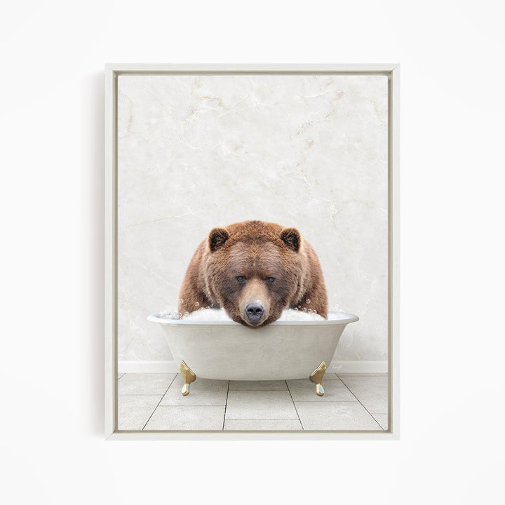 A brown bear is sitting in a white bathtub, appearing to be enjoying a relaxing bath.