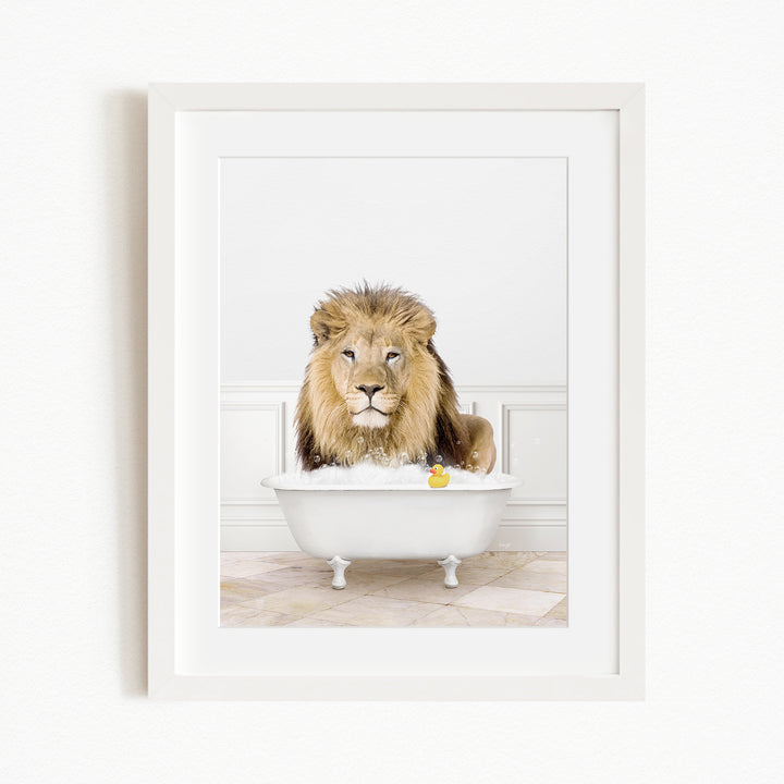 A lion sitting in a white bathtub filled with water and bubbles, with a yellow rubber duck floating in the water.