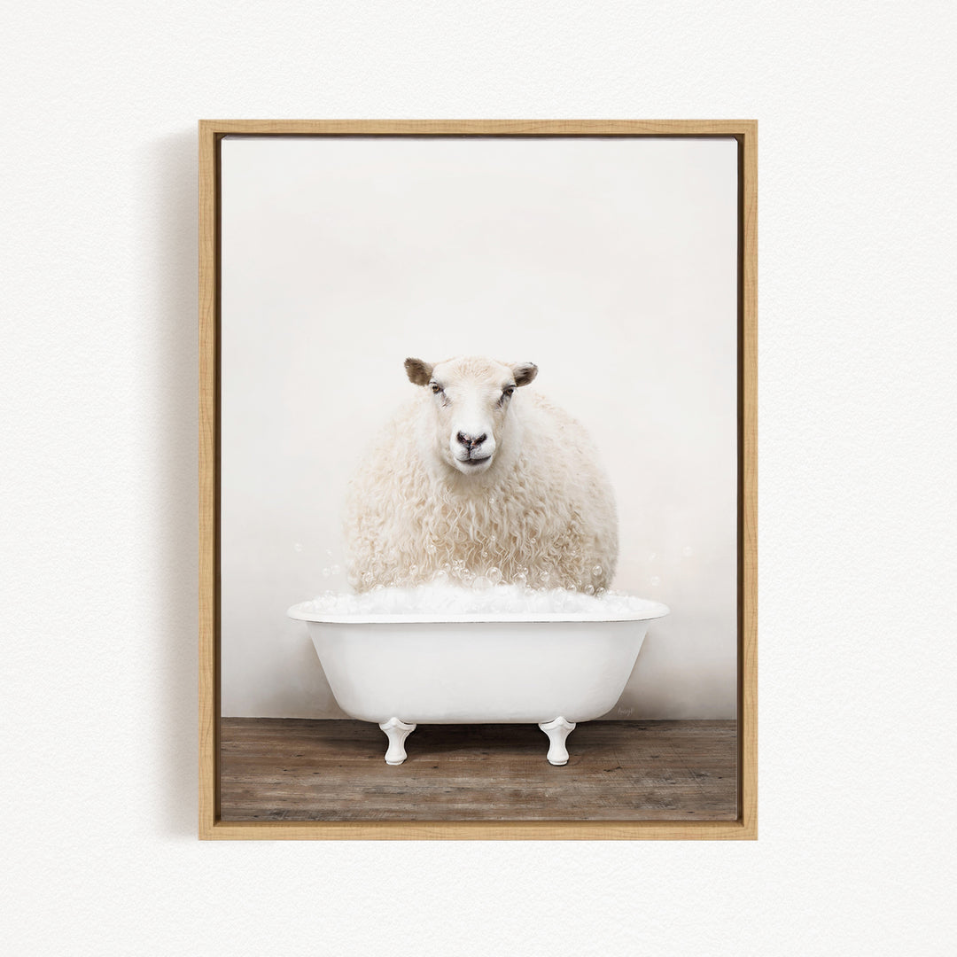 A fluffy white sheep sits in a white bathtub filled with bubbles, looking directly at the camera.