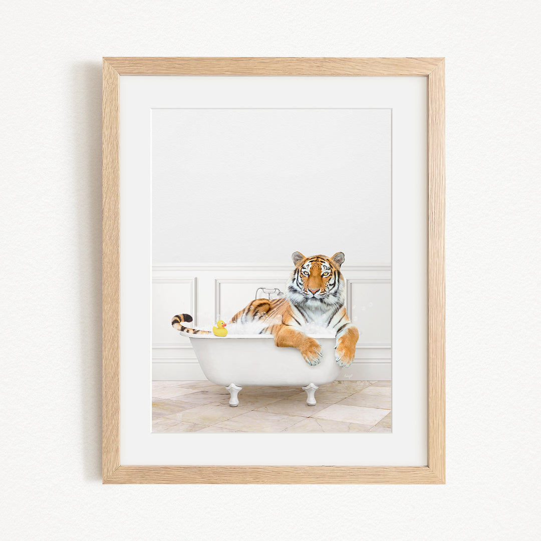 A tiger is sitting in a white bathtub, surrounded by various objects, including a rubber duck and a yellow toy.