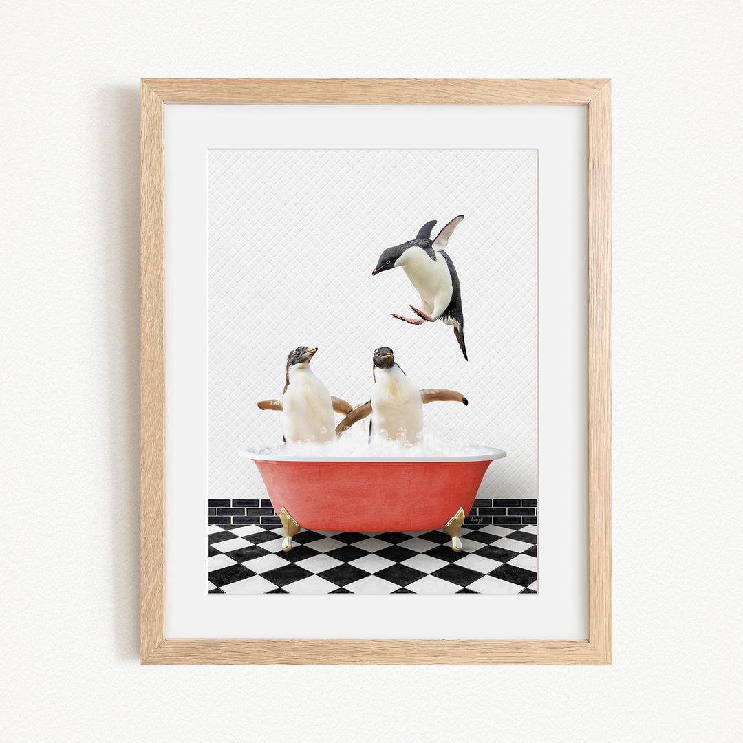 A framed image depicting two penguins sitting in a red bathtub, with one penguin flying towards the other.