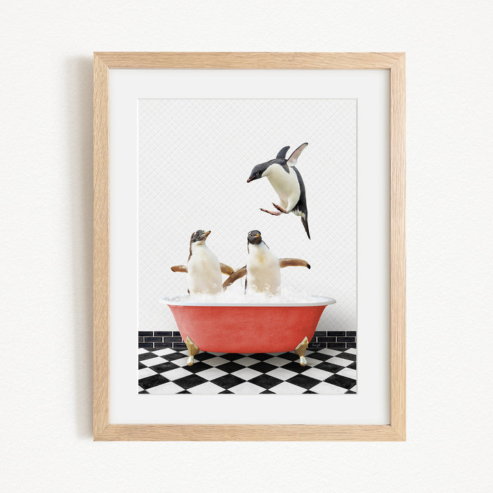 A framed image depicting two penguins sitting in a red bathtub, with one penguin flying towards the other.