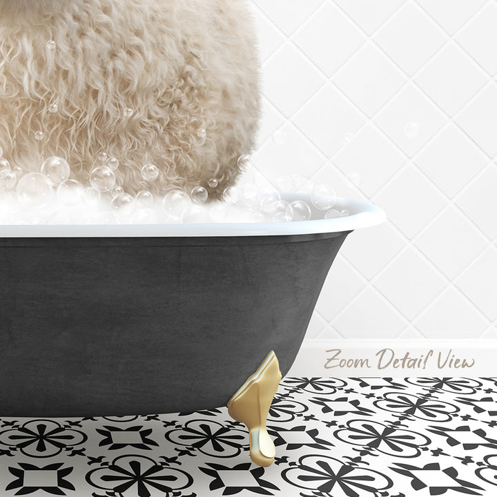 A fluffy white dog is sitting in a bathtub filled with bubbles, with a gold bathtub faucet and a patterned tile floor visible in the background.