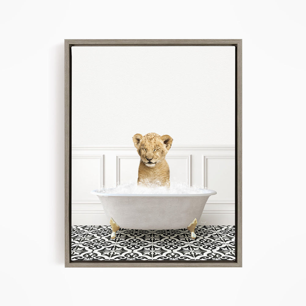 A young lion cub sitting in a white bathtub filled with water, surrounded by a black and white patterned floor.