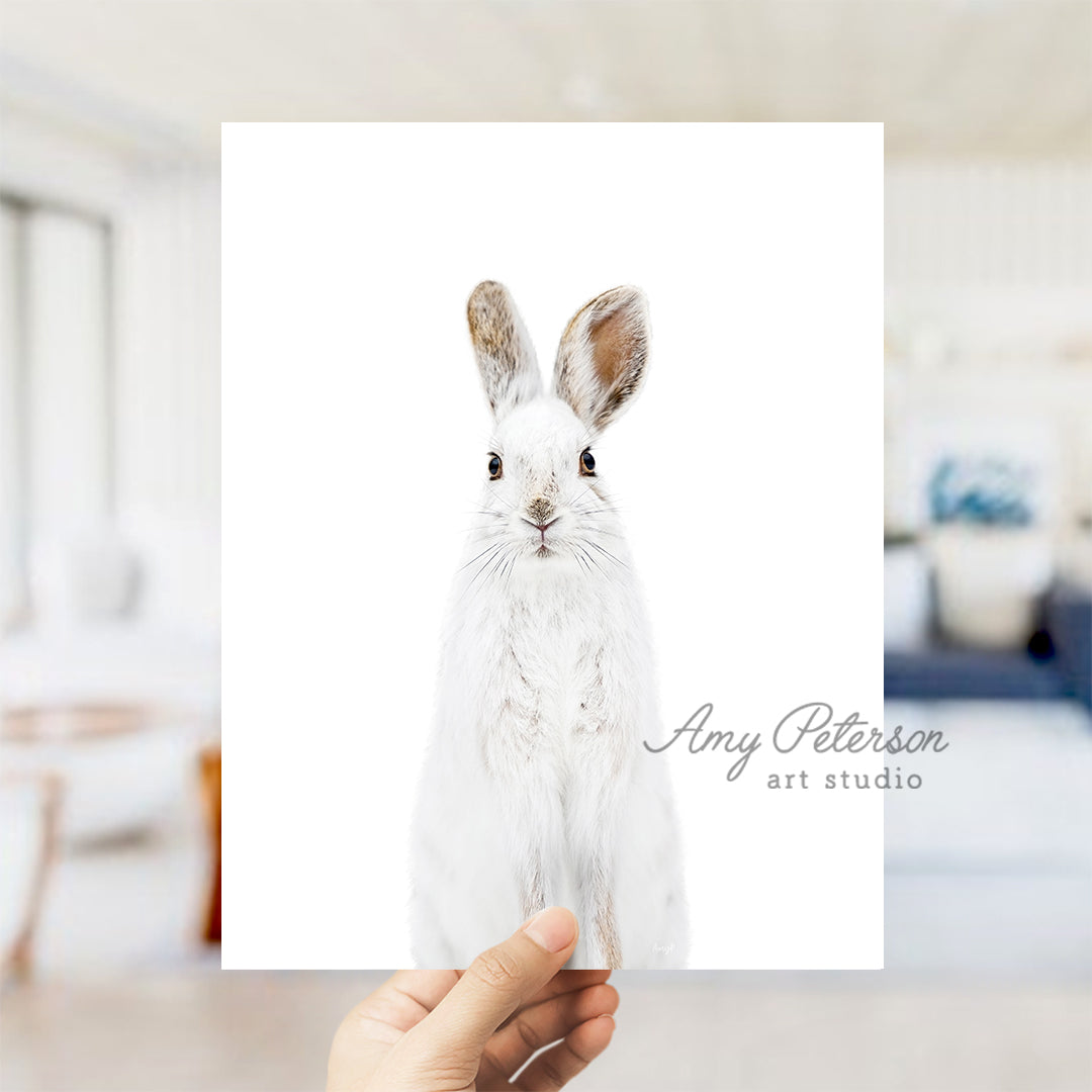 a person holding up a card with a picture of a rabbit