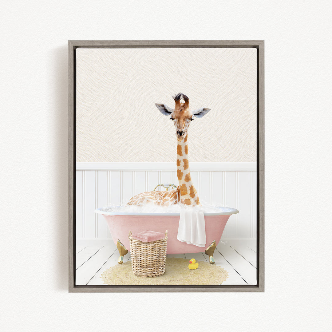 A giraffe is sitting in a pink bathtub filled with water, surrounded by a basket of toys and a yellow rubber duck.