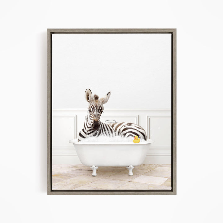 A zebra is sitting in a white bathtub, surrounded by a yellow rubber duck.