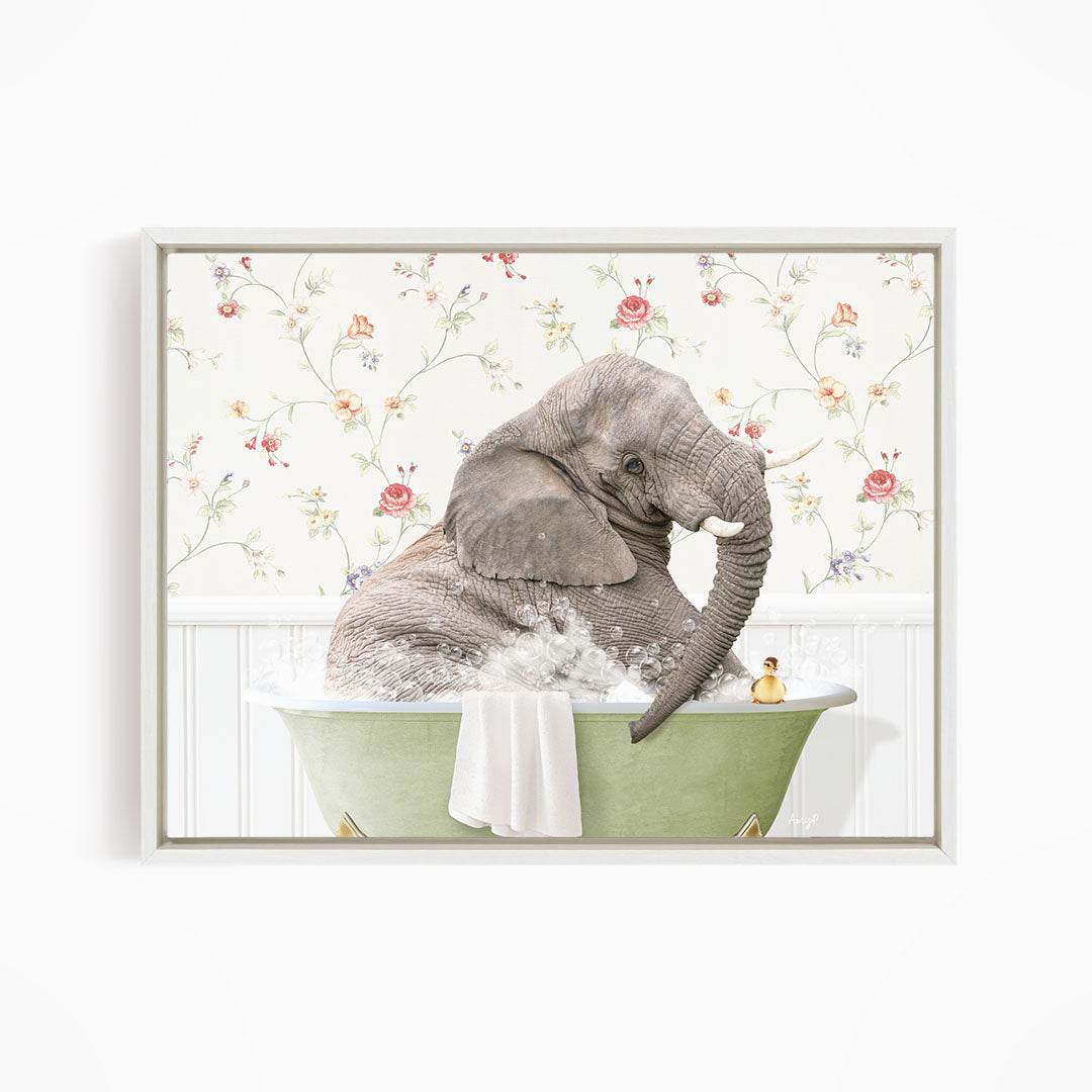 A gray elephant is sitting in a green bathtub filled with water, surrounded by a floral patterned wall.
