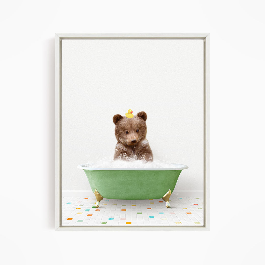 A brown bear sitting in a green bathtub filled with bubbles, with a yellow rubber duck floating on the water.