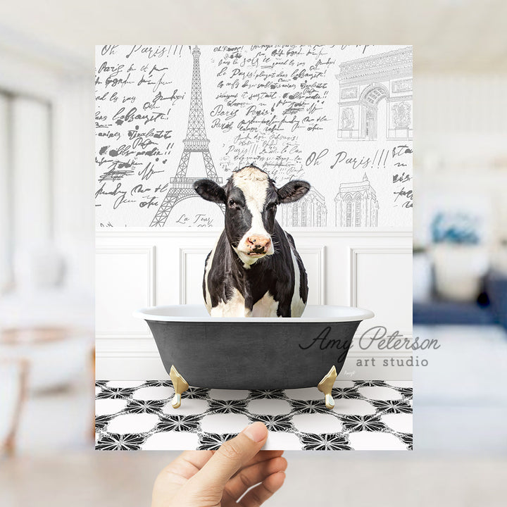 a person holding up a card with a picture of a cow in a bathtub