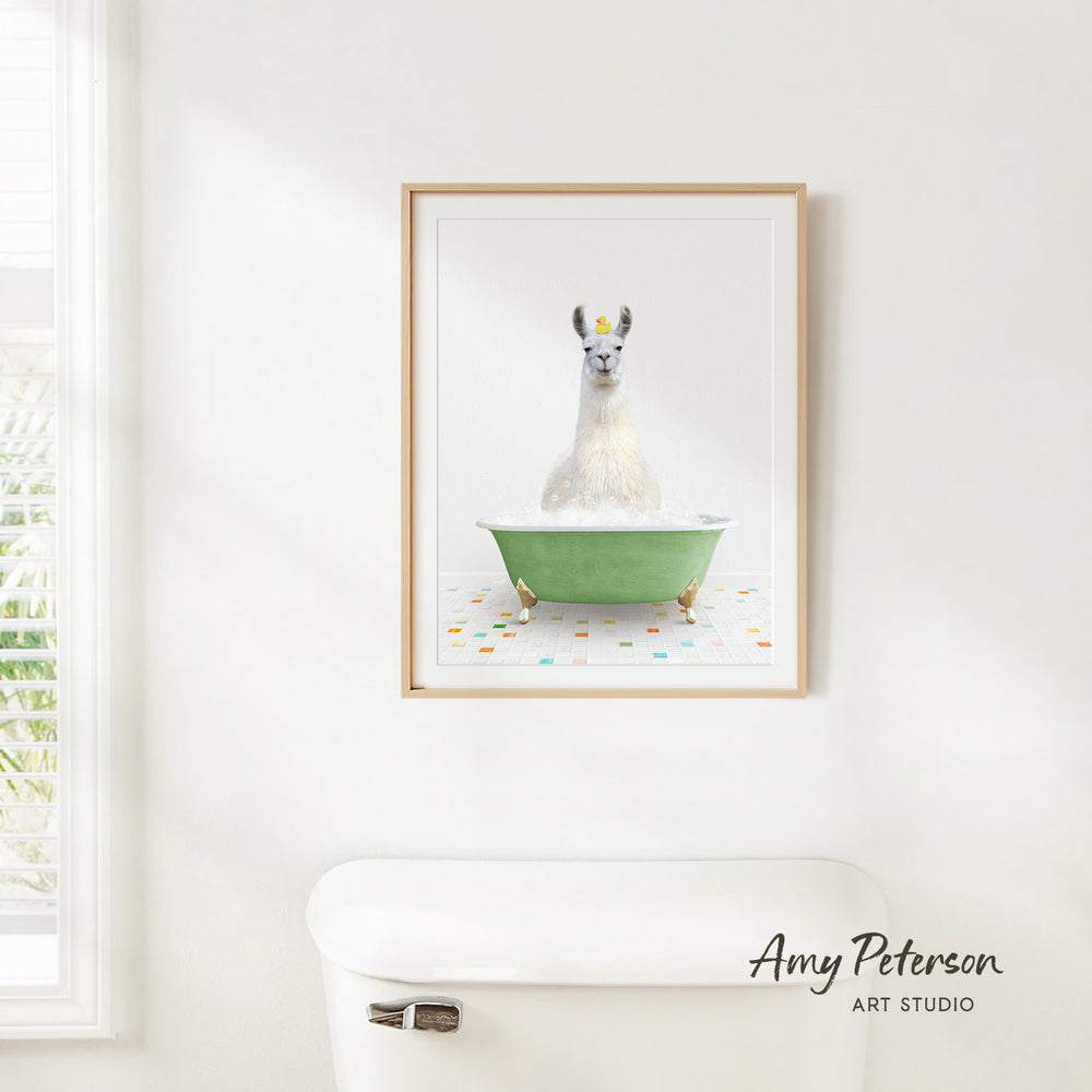 A framed image of a white llama sitting in a green bathtub, with colorful tiles on the floor.