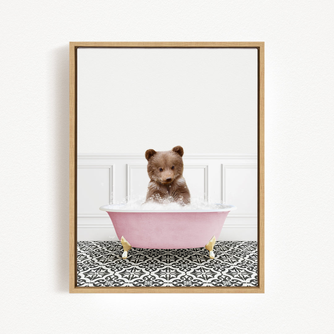 A cute brown bear sitting in a pink bathtub filled with bubbles, surrounded by a black and white patterned floor.