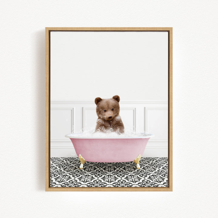 A cute brown bear sitting in a pink bathtub filled with bubbles, surrounded by a black and white patterned floor.