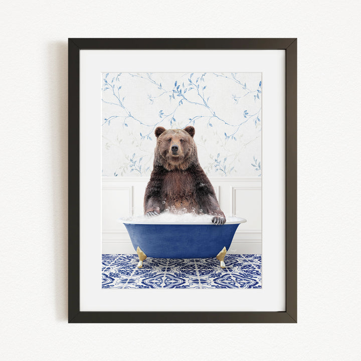 A brown bear sitting in a blue bathtub filled with water, surrounded by a blue and white floral patterned wall.