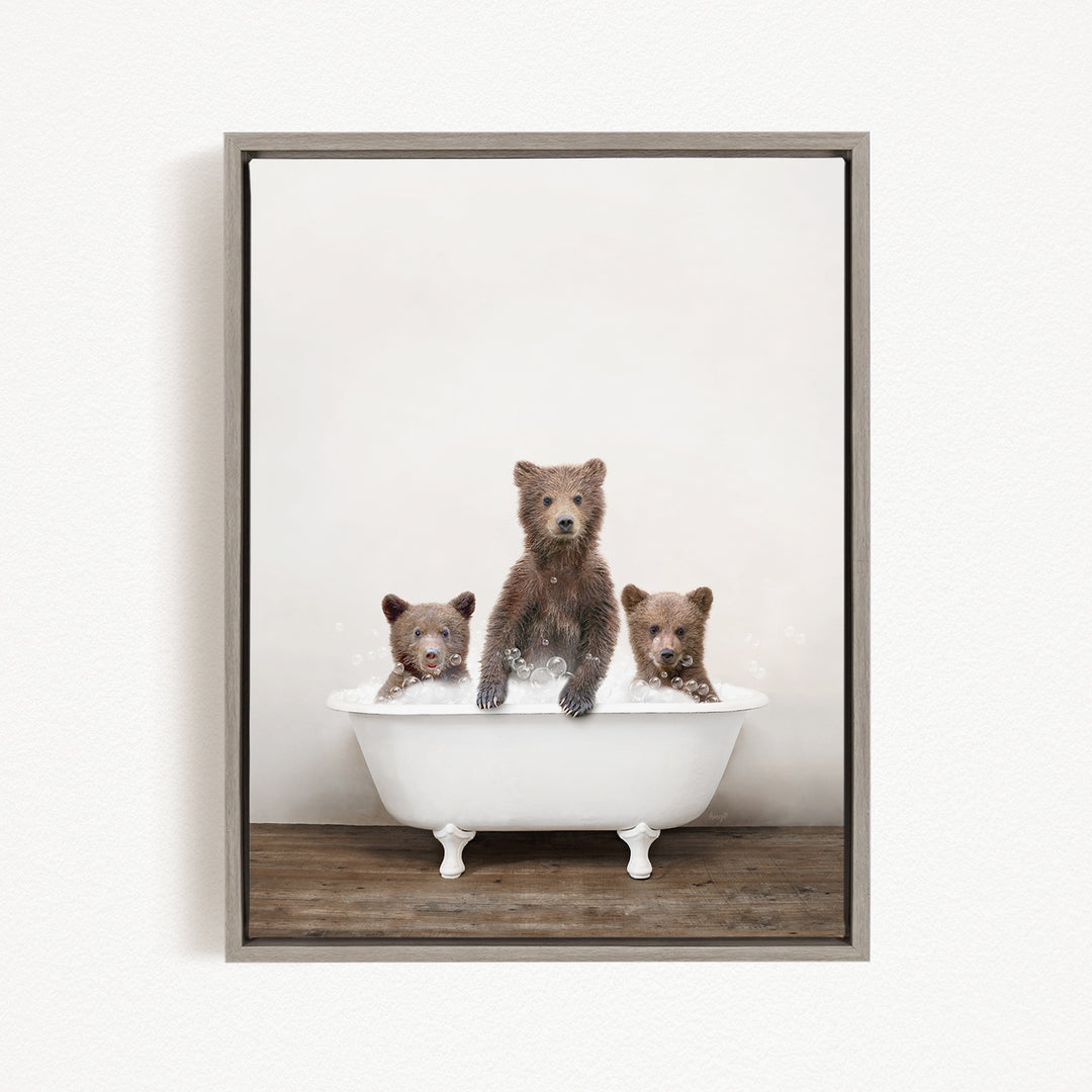 A framed image depicting three bears sitting in a white bathtub, with one bear sitting in the center and the other two bears sitting on either side.