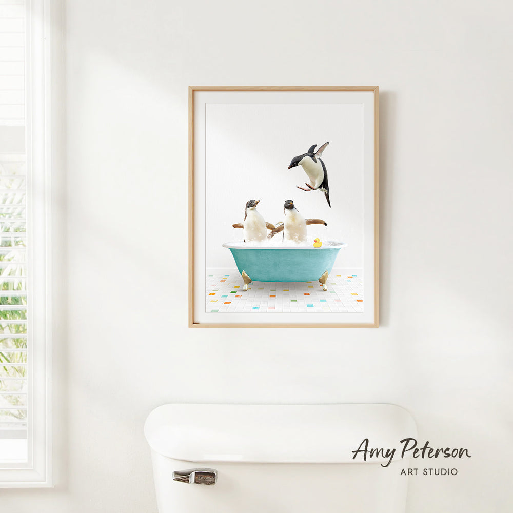 A framed image of three penguins sitting in a bathtub, with one penguin flying out of the tub.