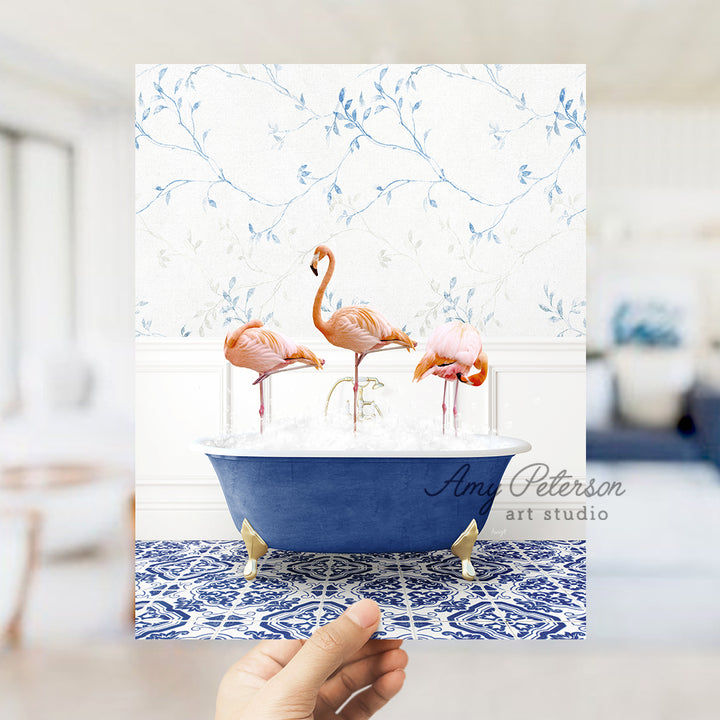 a person holding up a card with flamingos in a bathtub