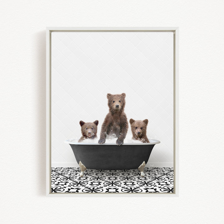 Three adorable brown bears sitting in a black bathtub, with one bear sitting in the center and the other two sitting on either side.