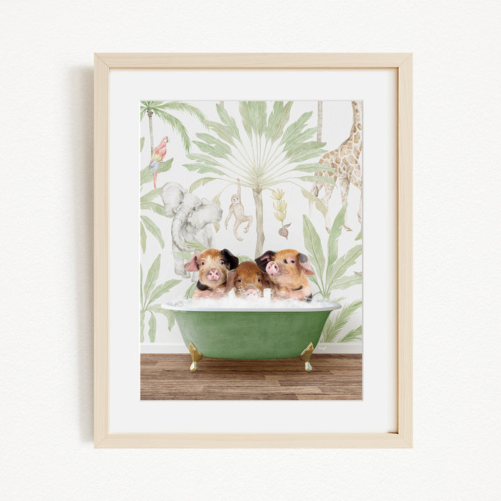 A framed print depicting three pigs sitting in a green bathtub, surrounded by a tropical jungle wallpaper.