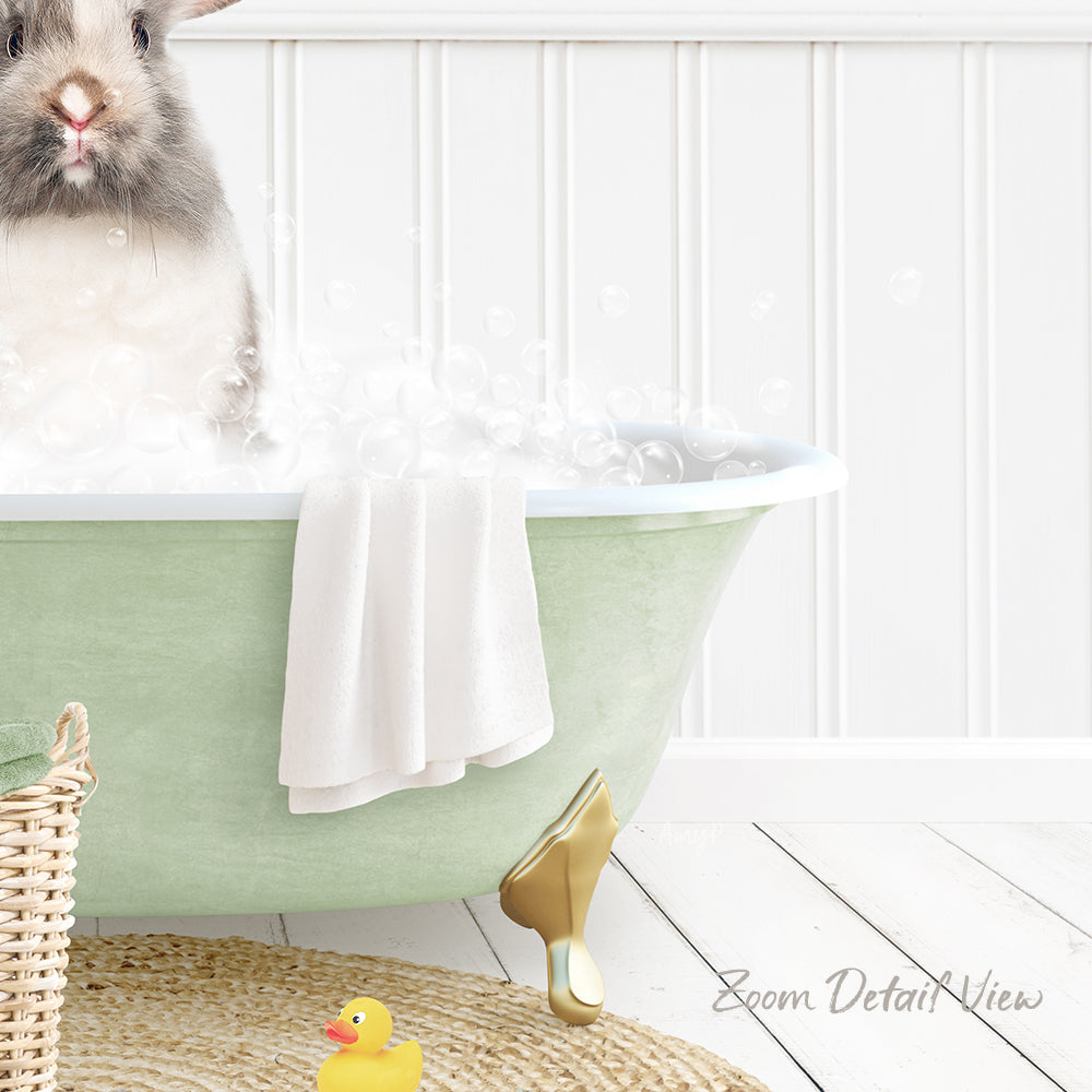 A fluffy gray rabbit sitting in a green bathtub filled with bubbles, surrounded by a yellow rubber duck and a white towel.