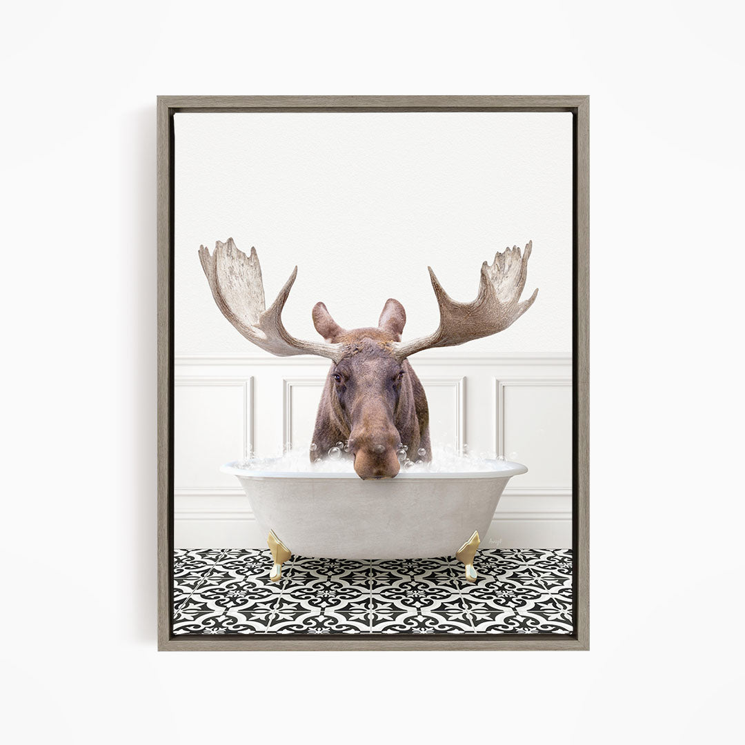 A moose with large antlers is sitting in a bathtub filled with water, creating a whimsical and humorous scene.