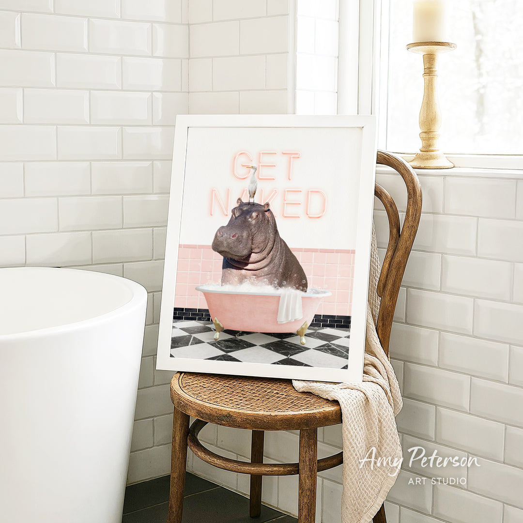 A framed image of a hippopotamus sitting in a pink bathtub, with the text "GET NICKED" displayed on the frame.