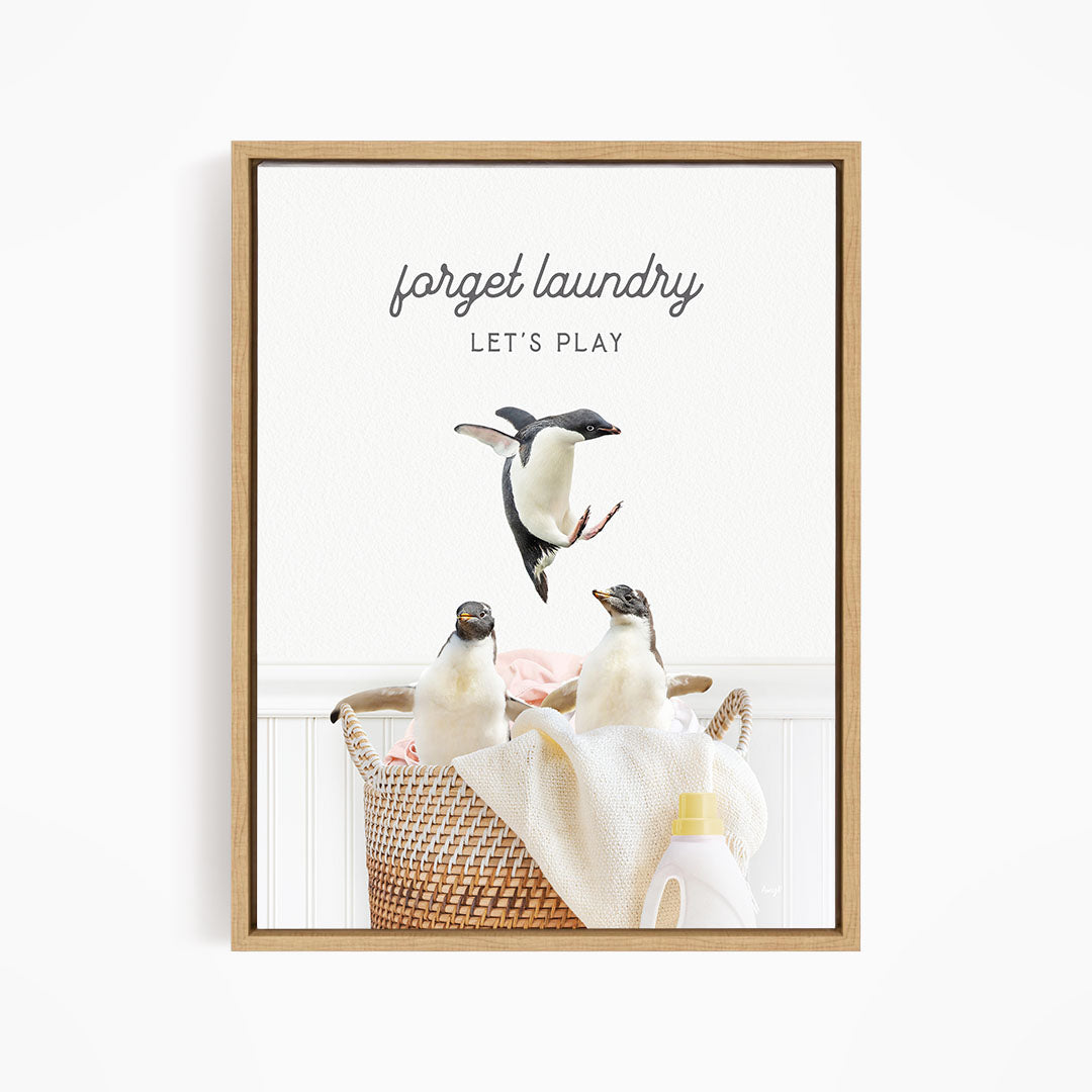 three penguins sitting in a basket filled with laundry, with one penguin jumping out of the basket.