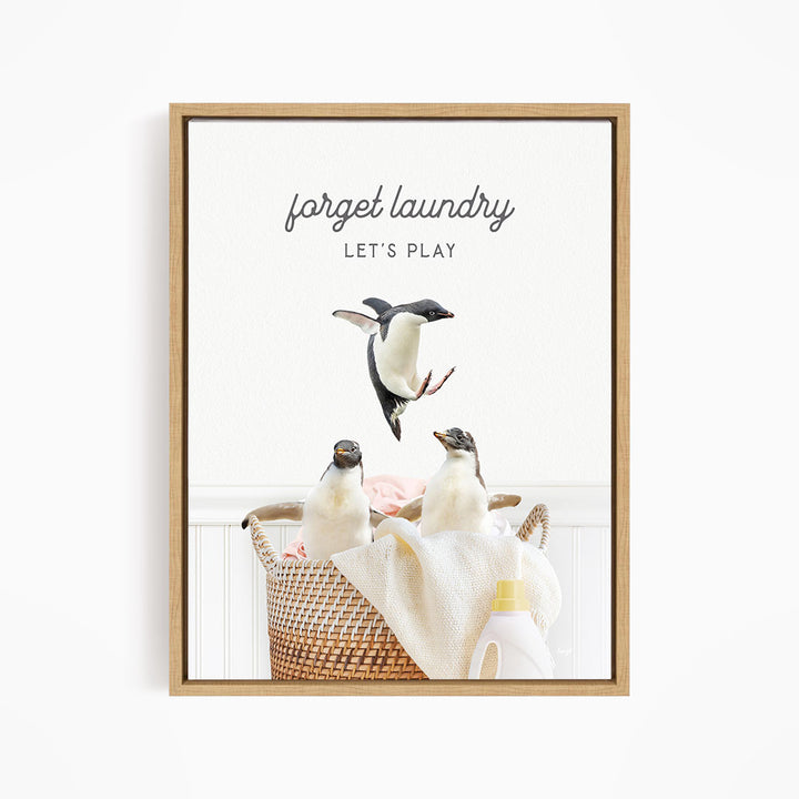 three penguins sitting in a basket filled with laundry, with one penguin jumping out of the basket.