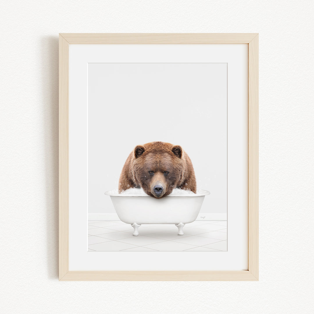 A brown bear is sitting in a white bathtub, appearing to be enjoying a relaxing bath.