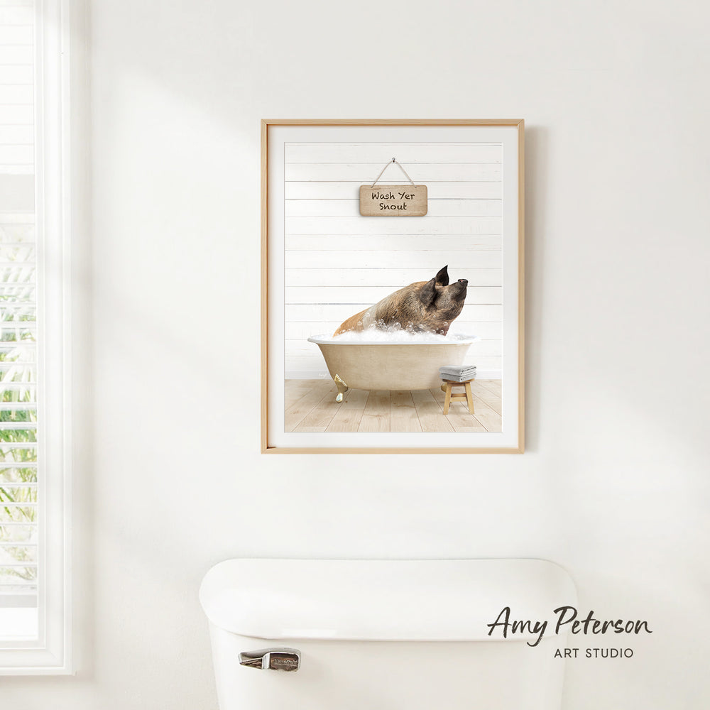 A framed image of a pig sitting in a bathtub, with a sign above it that says "Wash Your Pig".