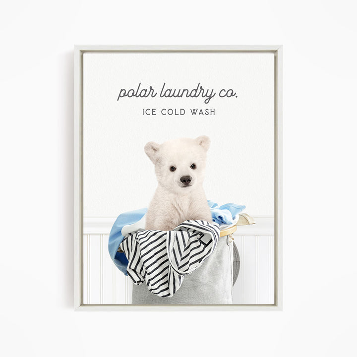 A white polar bear sitting in a laundry basket filled with clothes, with the text "polar laundry co. ICE COLD WASH" displayed above the image.