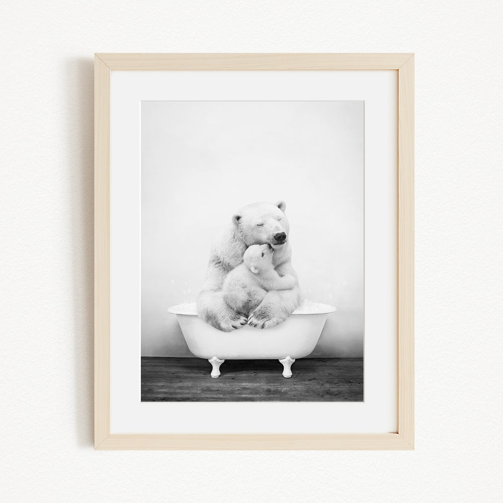 A black and white photograph of two polar bears sitting in a bathtub, with one bear appearing to be hugging the other.