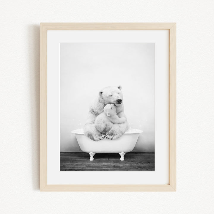 A black and white photograph of two polar bears sitting in a bathtub, with one bear appearing to be hugging the other.