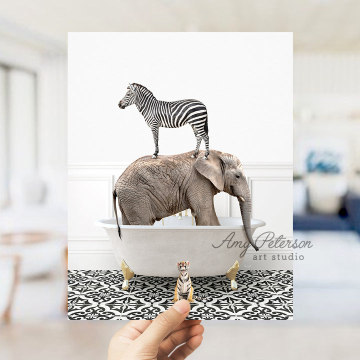 a hand holding a card with a zebra and an elephant on top of a bath