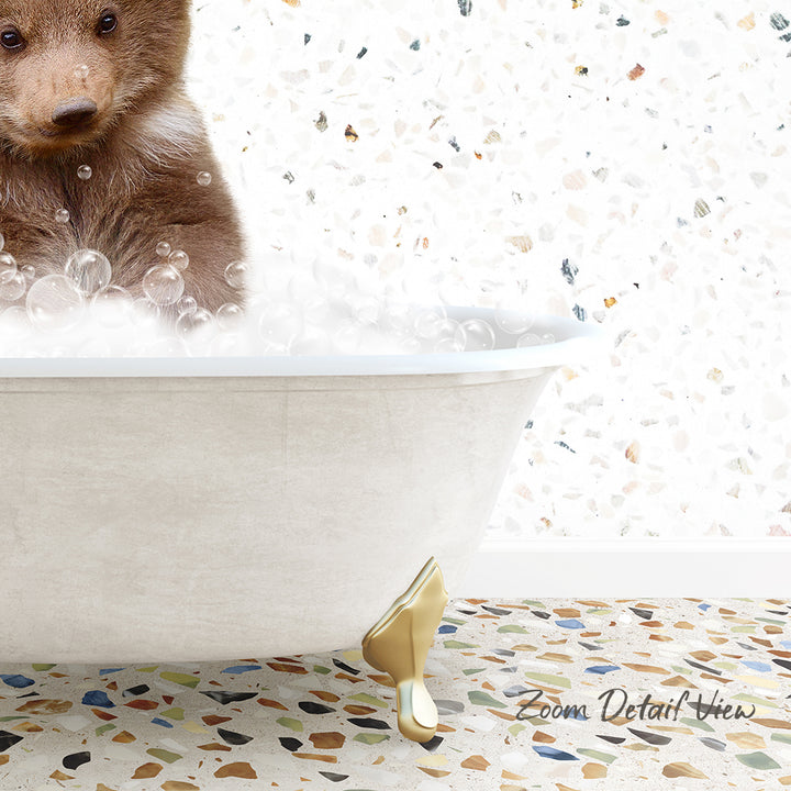 A brown bear is sitting in a white bathtub filled with bubbles, with a mosaic floor in the foreground.