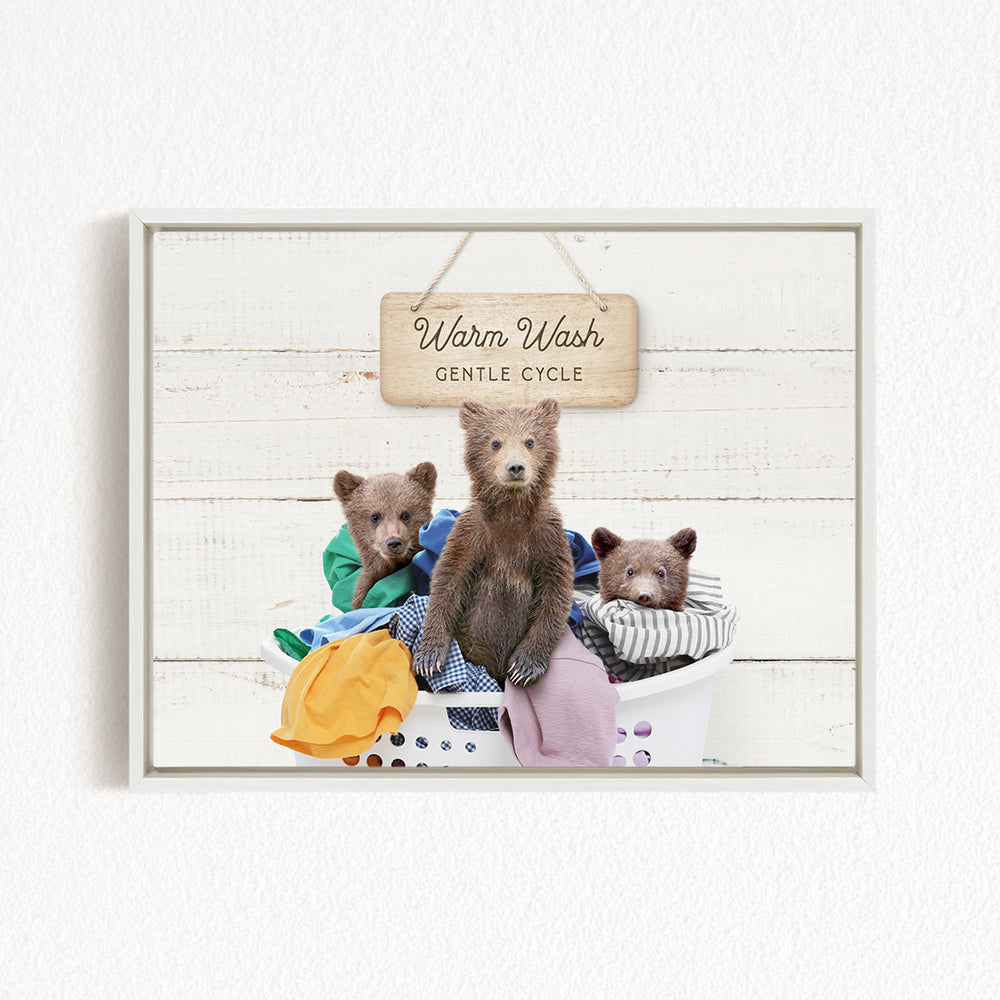 A framed image depicting three bears sitting in a laundry basket, with a sign above them that reads "Warm Wash Gentle Cycle".